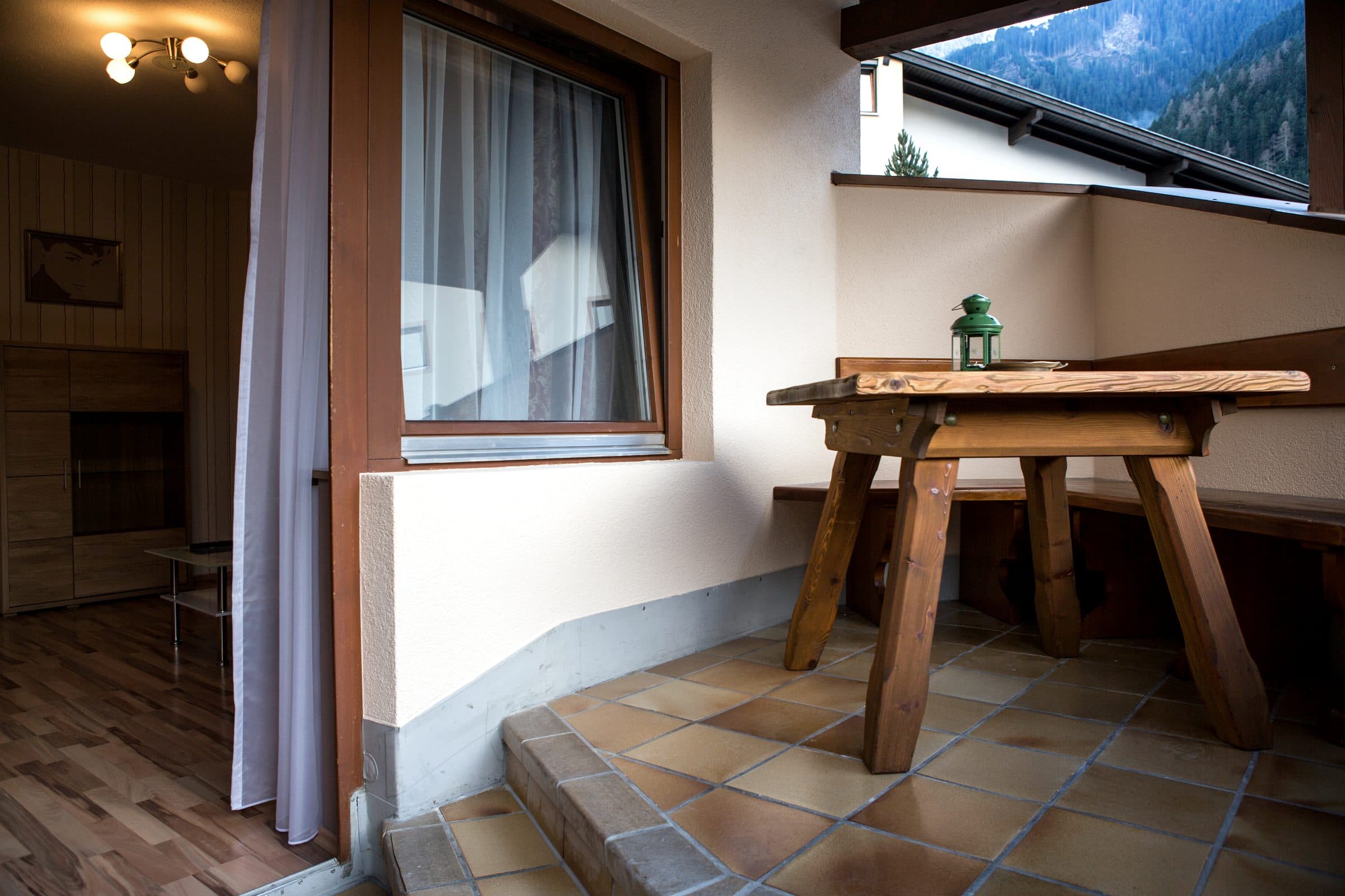 Balkon mit Holztisch und Blick auf die Berge